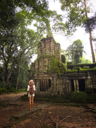 Solo Female Traveler At Mossy Angkor Jungle Temple Ruins In Cambodiaの写真素材