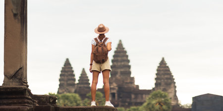 Backpacker Woman Looking At Angkor Wat, Iconic Cambodia Temple Viewの写真素材