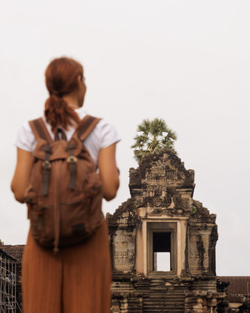 Backpacker Gazes at Angkor Wat Gopura with Palm, Cambodia Travel Conceptの写真素材