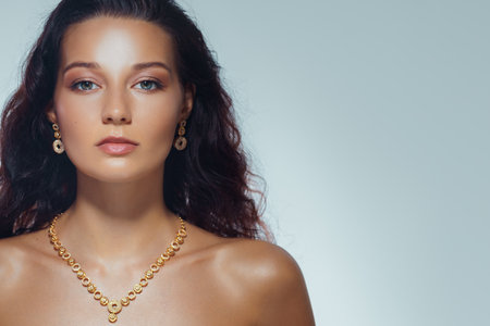 Beauty Banner With Glowing Skin and Elegant Gold Jewelry on Brunette Modelの写真素材