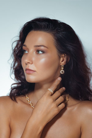 Luxury Beauty Portrait of Woman Wearing Gold Accessories and Soft Makeupの写真素材