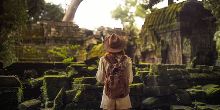 Woman Traveler Facing Mossy Angkor Jungle Temple Ruins Panorama Bannerの写真素材