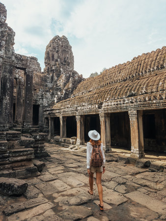 Female Traveler Walking In Bayon Temple Courtyard, Angkor Thom, Cambodiaの写真素材
