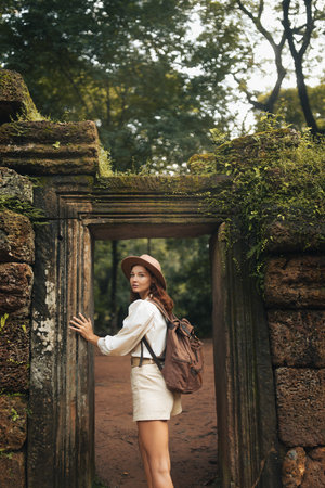 Female Traveler At Ancient Jungle Temple Gate In Historic Cambodia Ruinsの写真素材