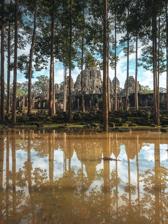 Angkor Thom s Bayon Temple Through Tall Trees, Reflections In Poolの写真素材
