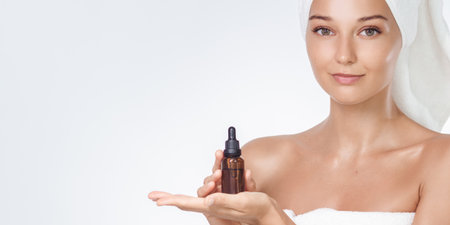 Spa Skincare Concept Woman Presenting Face Serum In Amber Dropper Bottleの写真素材