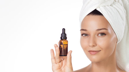 Woman With Towel Turban Showing Amber Serum Dropper Skincare Bottleの写真素材
