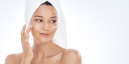Moisturizing Face Cream on Caucasian Woman, Towel Wrap, Skincare Ad Bannerの写真素材