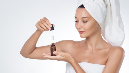 Skincare Serum Dropper Over Palm, Towel-Wrapped Woman On White Bannerの写真素材