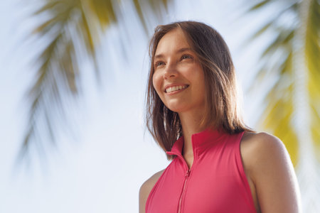 Freckled Woman Smiling in Pink Sportswear With Tropical Background