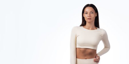 Woman In Seamless Sports Uniform Standing In Studio With Space For Textの写真素材