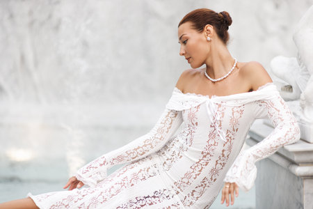 Elegant Woman In White Lace Dress By Marble Fountain For Advertisingの写真素材
