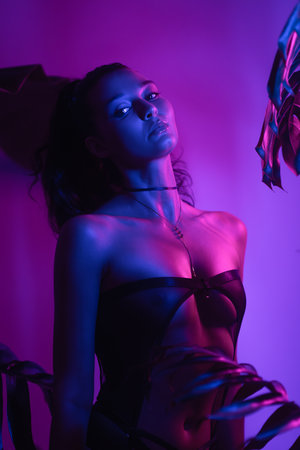 Fashion Portrait of Woman in Lingerie With Neon Light and Foliageの写真素材