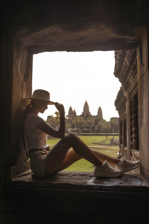 Silhouette Traveler In Temple Window Overlooking Angkor Wat, Cambodiaの写真素材