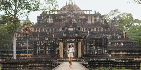 Smiling Backpacker Walking To Baphuon Temple, Angkor Thom Cambodiaの写真素材