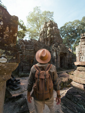 Man With Hat and Backpack Explores Ancient Ruins of Ta Som Temple