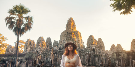 Woman Traveler Posing in Front of Bayon Temple at Sunset, Angkor Thomの写真素材