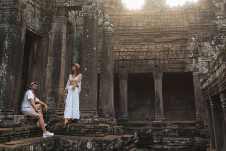 Couple Exploring Ancient Bayon Temple Ruins in Cambodia During Vacationの写真素材