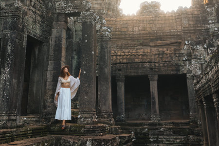 Female Traveler Exploring Bayon Temple Courtyard at Sunriseの写真素材