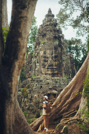 Bayon Face Tower With Female Traveler Among Giant Roots, Angkor Thomの写真素材