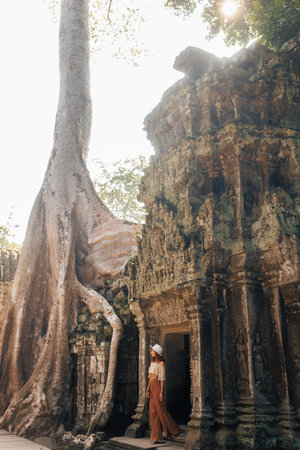 Young Woman Visiting Ancient Temple Entrance In Cambodia Jungle Ruins
