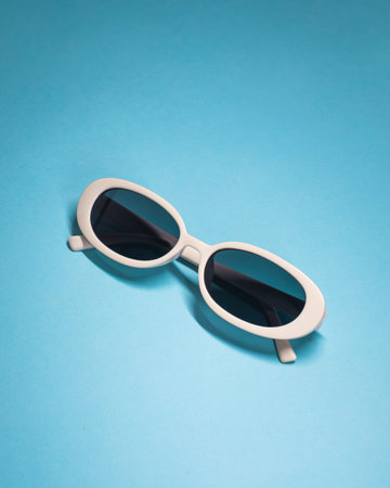 White Oval Sunglasses On Blue Background With Copy Space, Studio Shotの写真素材
