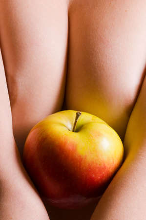 Nude young woman holding appleの写真素材