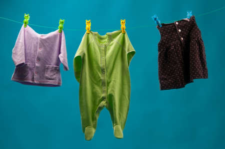 Baby clothes on the line, on a blue backgroundの写真素材