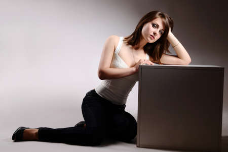 beautiful girl in jeans and a gray cubeの写真素材