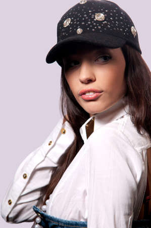 pretty girl in a baseball cap with a gray backgroundの写真素材