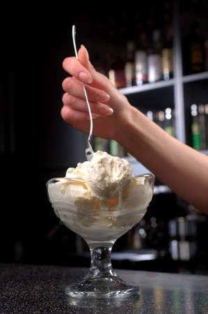 a glass of ice-cream stands on the barの写真素材