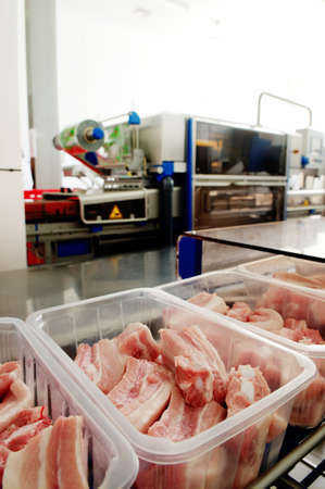 Workers taking the lumps of meat in a containerの写真素材