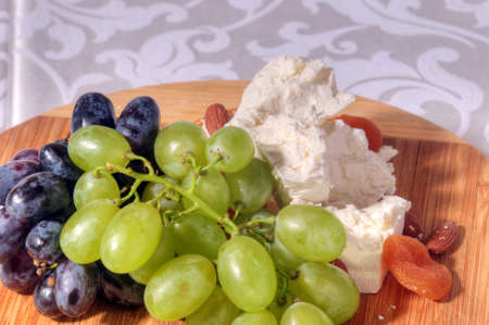 grapes and cheese on the table in a restaurantの写真素材