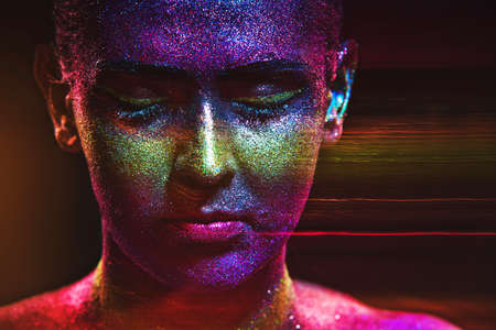 Glitter makeup on a beautiful woman face on a black background. Creative Contemporary Designの写真素材