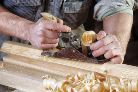 Man hands with carpenters plane on wooden 