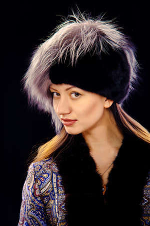 Winter girl with white fur hat wearing warm fur coat
