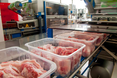 Workers taking the lumps of meat in a containerのeditorial素材