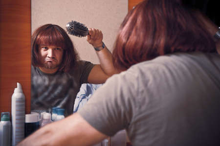 Man combs wig. Beauty salon, dressing room.の写真素材