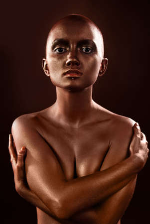 beautiful woman with bodypainting bronze on a black backgroundの写真素材