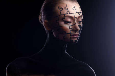 puzzles painted on a beautiful woman's faceの写真素材