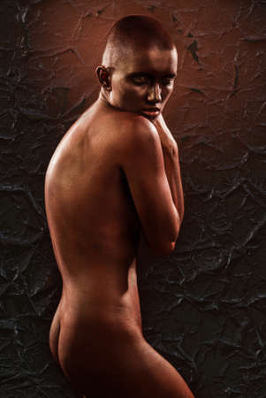 beautiful woman with bodypainting bronze on a black background with cracked paintの写真素材