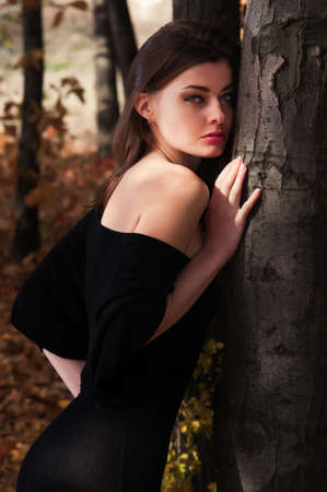 A young beautiful woman out alone in the autumn forestの写真素材