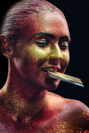 Glitter makeup on a beautiful woman face on a black background. Creative Contemporary Design