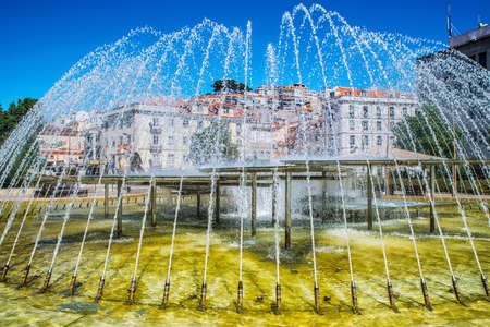 Fountain in the center of the city. Romantic Lisbon street with the typical old buildings and new buildingsの写真素材