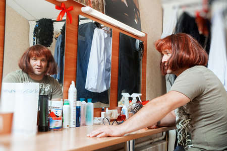 Man combs wig. Beauty salon, dressing room.の写真素材