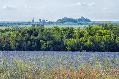 landscape with a field, the coal mine waste heaps and on the horizonの写真素材