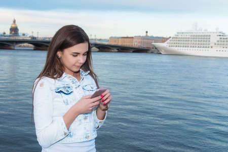 girl walking along the promenade and talking on the phoneの写真素材