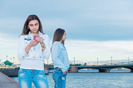 Two young beautiful girls are walking through the cityの写真素材