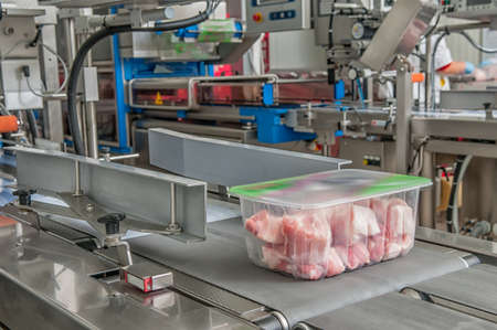 Workers taking the lumps of meat in a containerのeditorial素材