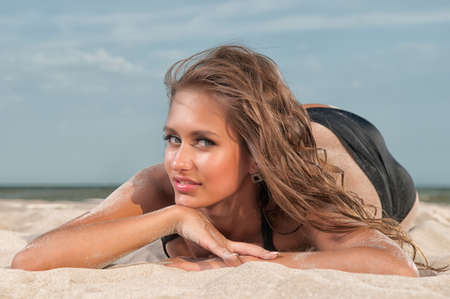 beautiful woman in a bathing suit on the beach at sunsetの写真素材